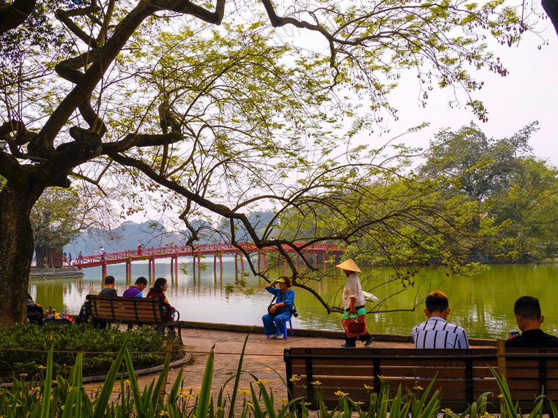 Hanoi göl kenarında oturan turistler