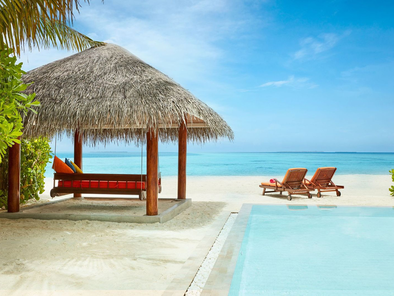 Maldivler'de özel sahil villasının denize karşı havuz ve salıncağı