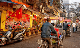 Vietnam Hanoi'de uc tekerlekli bisiklete binen turistler